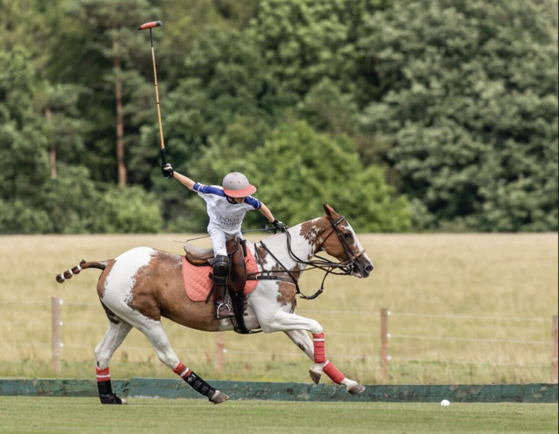 Young polo player celebrating on paint horse